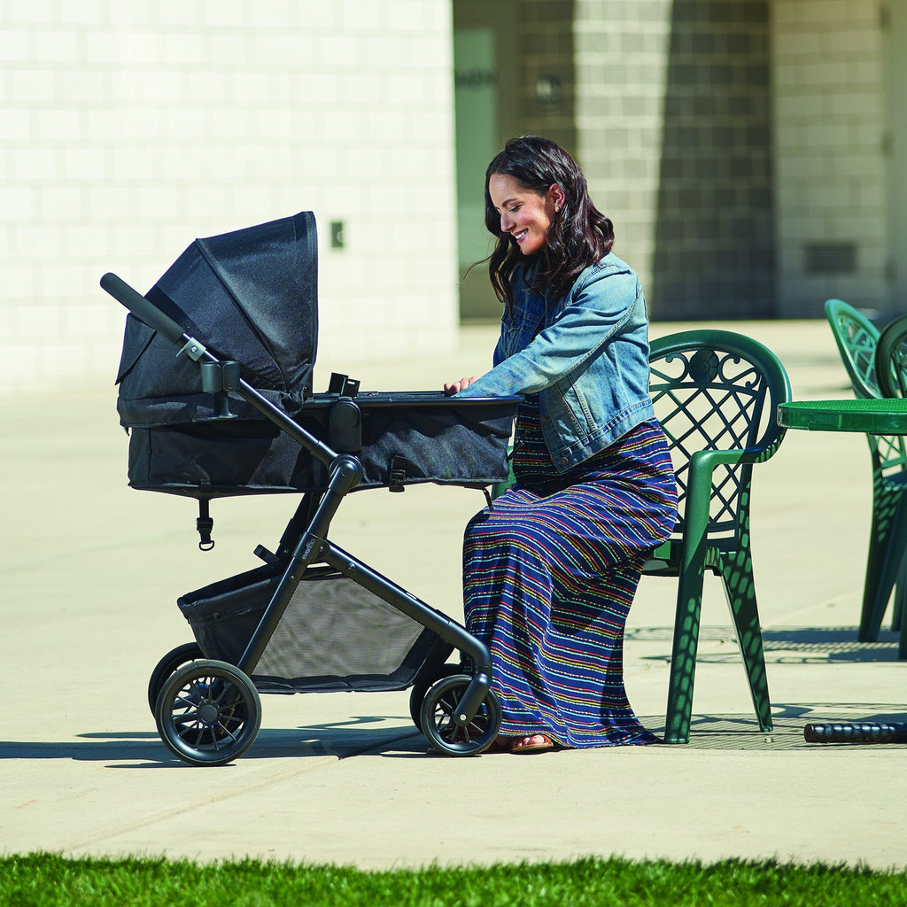 Evenflo Pivot Modular Travel System with SafeMax Car Seat, stroller with car seat attached, featuring adjustable handle and storage basket.